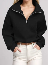 Woman in half zip long sleeve sweatshirt with white pants and belt