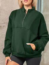 Dark green half zip stand collar sweatshirt with exposed seams, front pockets, slightly stretchy fabric, machine wash safe