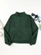Dark green half zip stand collar fleece sweatshirt with exposed seams, slightly stretchy fabric, two side pockets, machine wash safe