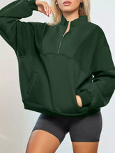 Dark green oversized half zip stand collar sweatshirt with exposed seams front pockets and slightly stretchy fabric machine wash safe