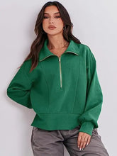 Woman in green half zip collared sweatshirt and gray cargo pants