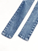 Blue denim fabric strips with visible stitching detail on a halter neck button-front denim dress