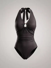 Black halter neck bodysuit with tied bow at neck and circular bust cutout in ruched one-piece design
