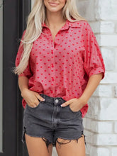 A pink heart print button-down shirt with subtle striped texture and scattered red heart patterns for stylish wear