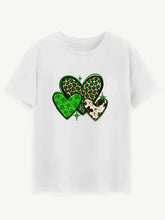 White short-sleeve round neck t-shirt with green leopard print and shamrock heart graphic