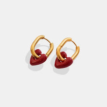 Pair of gold hoop titanium steel earrings with dangling red heart charms
