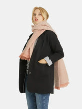 Woman modeling black blazer, heathered polyester scarf with raw hem, blue jeans