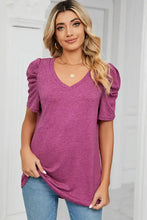 Woman in magenta heathered V-neck puff sleeve T-shirt with blue jeans