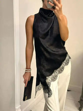 Black satin sleeveless high neck cami with lace trim along the asymmetrical hem perfect for elegant wear