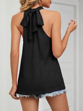 Back view of a black high neck tie halter neck top with tied bow and frayed hemline in lightweight fabric