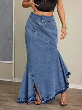 A medium-wash denim maxi skirt with asymmetrical slit, flared fishtail hem, and diagonal seam detailing