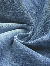 Blue denim fabric with classic twill weave and subtle texture for high waist bootcut jeans material close-up