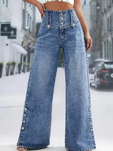 High waist button decor wide leg jeans in faded blue denim with decorative buttons along front and side seams