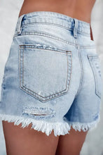 High waist denim shorts with distressed raw hem in light blue