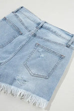 High waist denim shorts with distressed raw hem in light blue