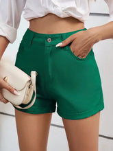 High waist denim shorts in kelly green with cuffed hems and button closure