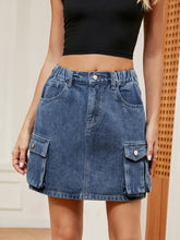High waist denim mini skirt in blue with two large cargo pockets and elastic waistband for comfortable fit