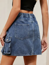 Blue high waist denim skirt with elastic waistband and cargo pockets made of durable denim material