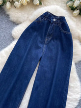 Dark blue denim high waist wide leg jeans with classic button closure and visible stitching for stylish wear