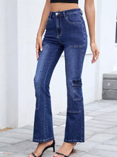 High-waisted bootcut dark blue denim jeans with prominent patch pockets on thighs and flared legs