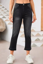 High-waisted black denim jeans with a distressed hem straight leg and frayed cuffs for a casual look