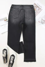 Black denim high-waisted jeans with a distressed hem straight leg cut and frayed hems for casual wear