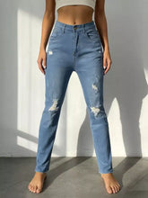 Light-wash high-waisted distressed jeans with ripped details on thighs and knees in denim material