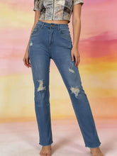 High-waisted distressed jeans in blue denim with frayed hems and ripped knee details
