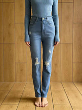 High-waisted light blue denim distressed jeans with ripped details on the thighs for a stylish casual look