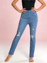 Light-wash high-waisted distressed jeans with intentional distressing and frayed patches on the knees