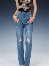 High-waisted distressed jeans in medium-wash blue denim featuring ripped details on knees and thighs