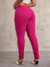 Bright fuchsia high-waisted skinny jeans with distressed frayed side panels for a trendy stylish look
