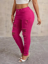 Bright fuchsia high-waisted distressed skinny jeans with frayed patches on thighs and knees in denim material