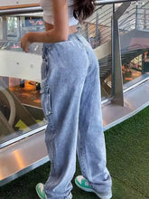 High-waisted drawstring cargo jeans in light-wash denim with elastic waistband and side pockets for casual wear