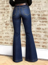 High-waisted dark blue denim flare jeans with moderate stretch and classic bell-bottom silhouette with contrasting stitching