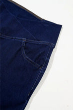Dark blue denim high-waisted flare jeans with visible zipper along waistband and stitched pocket details