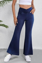 Navy blue high-waisted flare jeans with cross-front waistband and side pockets offering a perfect fit
