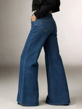 Blue denim high-waisted flare leg jeans shown from the back with classic pockets and a fitted silhouette