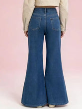 Back view of high-waisted blue denim flare leg jeans with classic back pockets and a fitted silhouette
