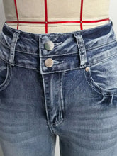 High-waisted flare leg jeans in faded blue denim with double-button front closure recommend measuring for fit