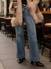 High-waisted flare leg jeans in light-wash denim with classic five-pocket design and rolled cuffs
