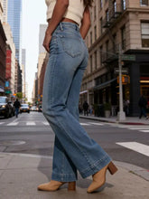 High-waisted flare leg jeans in light-wash denim with classic five-pocket design and slightly frayed hems