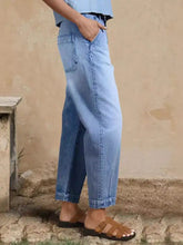High-waisted light-wash denim trousers with a relaxed fit wide-leg cut and cuffed hems for comfortable style