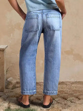 Light-wash high-waisted relaxed fit jeans with a wide-leg cut and classic back pockets shown from the back side