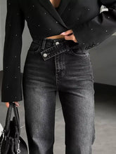 High-waisted black denim slit hem jeans featuring a distinctive front button closure and subtle distressing