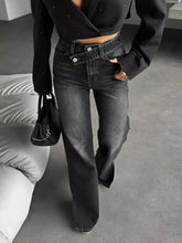 High-waisted slit hem jeans in black denim with wide-leg cut and decorative button closures for stylish wear