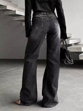 Black high-waisted wide-leg denim slit hem jeans with flared silhouette and subtle fading details