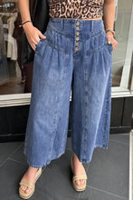 High-waisted wide leg button-fly jeans in medium blue denim with front pockets and a button-front closure