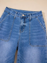 Blue denim high-waisted wide leg flare jeans with prominent front pockets and classic leg flare design