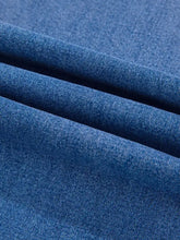 Blue denim high-waisted wide leg flare jeans showing textured woven fabric detail of leg flare jeans